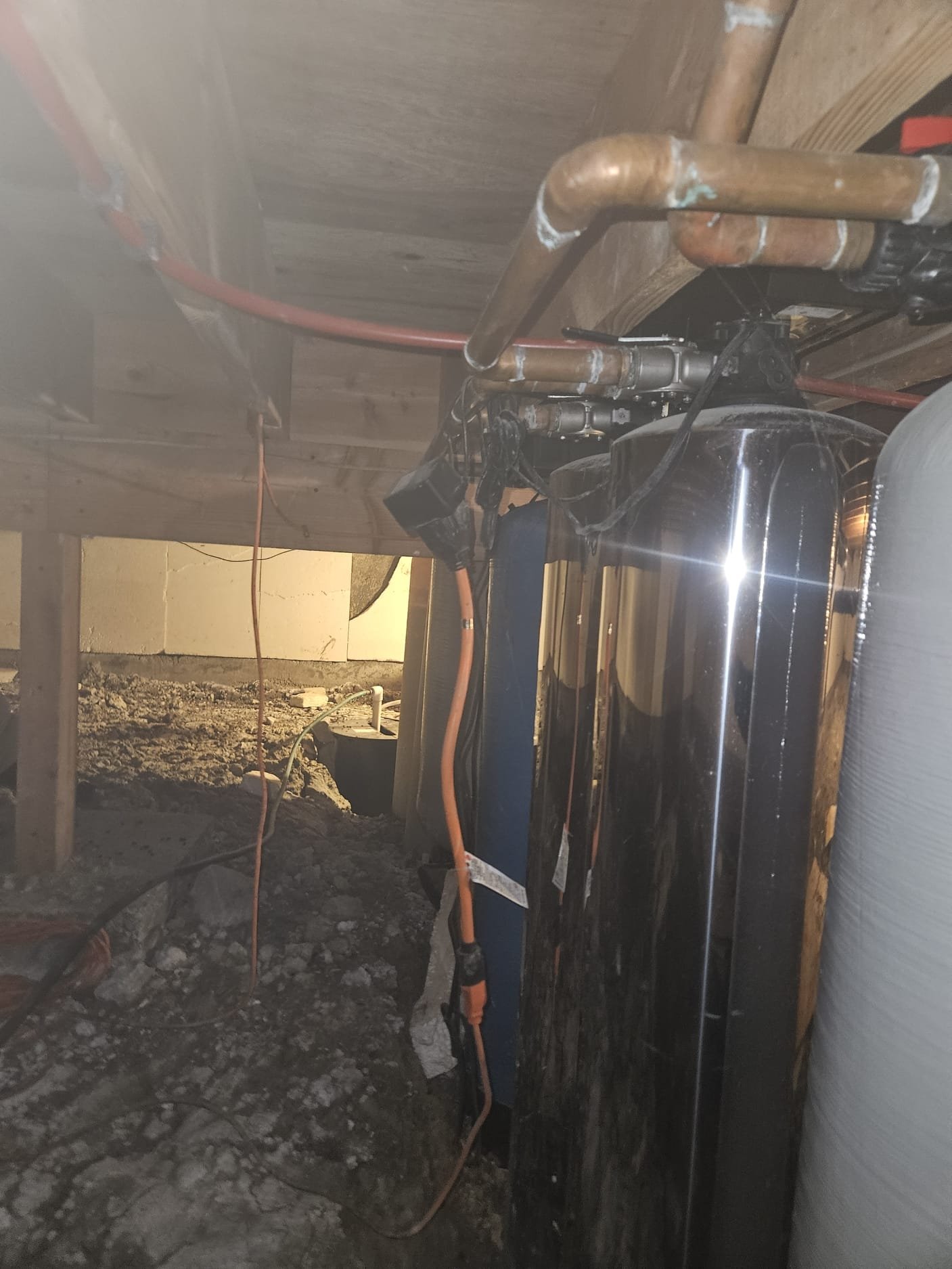 Old water treatment equipment installed in a crawl space at a Kremmling Colorado cabin