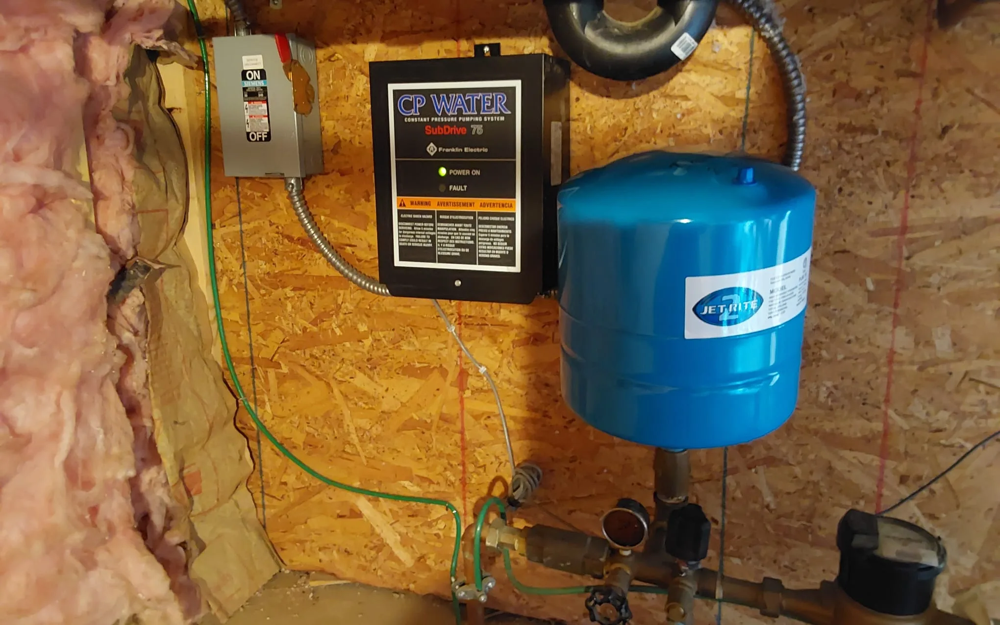 Original well control panel and pressure tank in a Fraser, Colorado crawlspace before replacement
