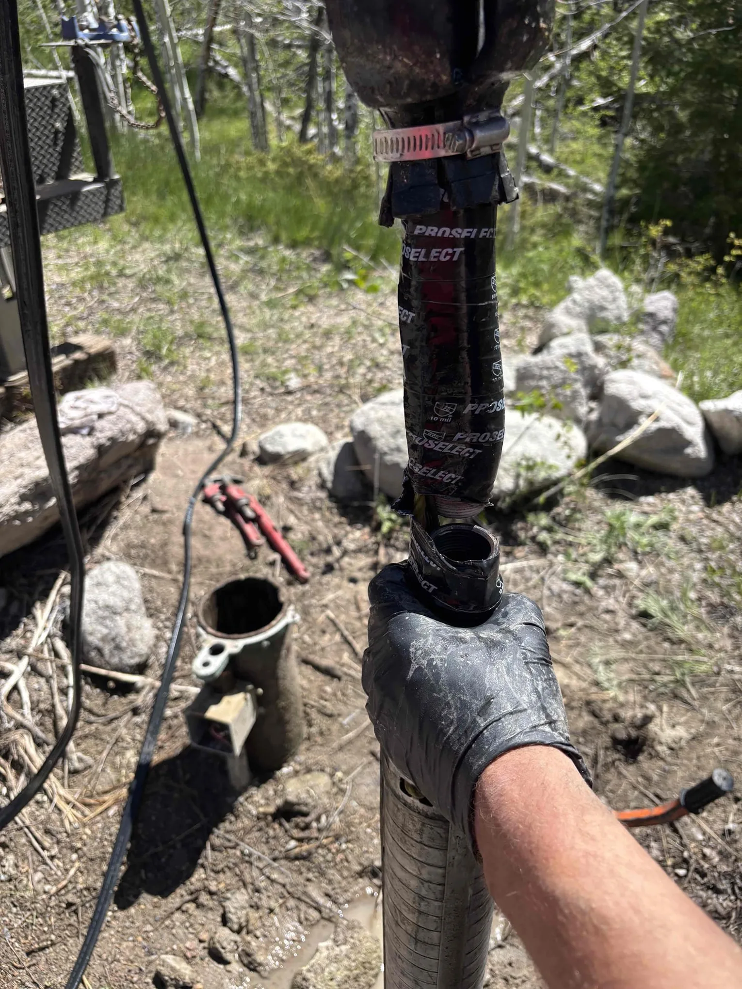 Old well pump and drop pipe being pulled from a well during recovery in Kremmling, Colorado